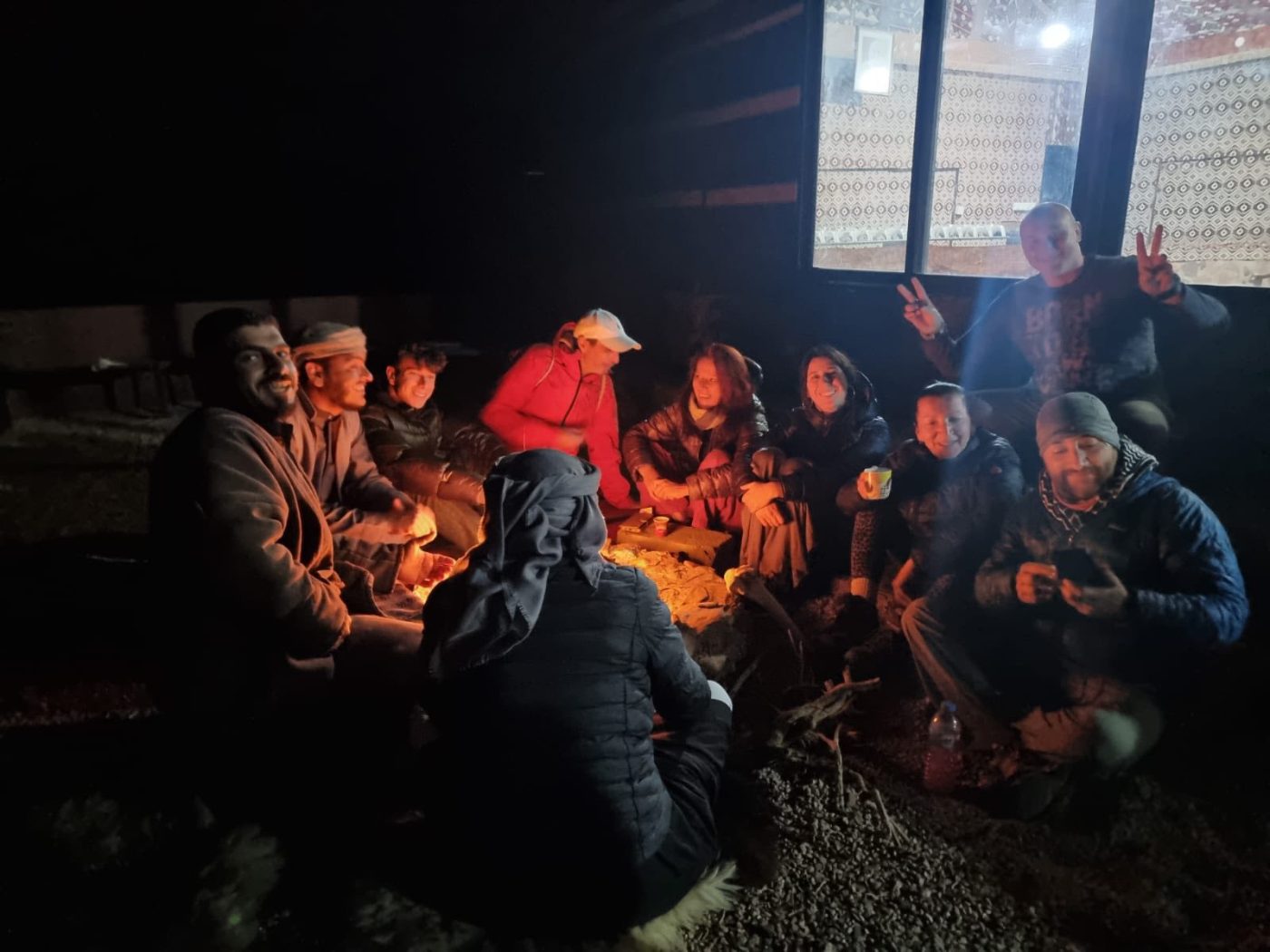 Travellers round the fire at a desert camp